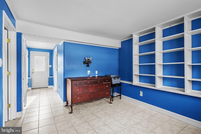 interior space with ornamental molding and light tile patterned floors