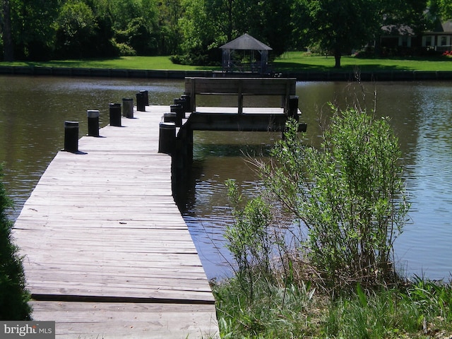 view of dock with a gazebo and a water view