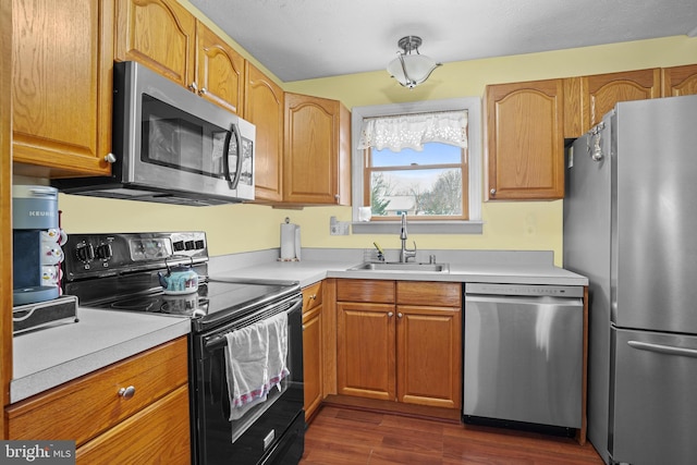 kitchen with sink, stainless steel appliances, and dark hardwood / wood-style flooring