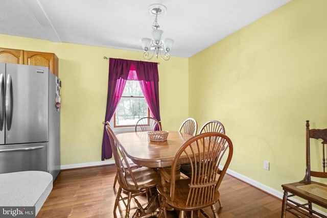 dining space with a chandelier and light hardwood / wood-style flooring