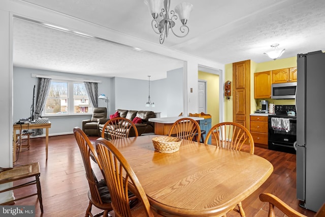 dining room with a textured ceiling and dark hardwood / wood-style flooring