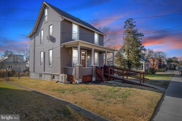 view of front of home with cooling unit, a porch, and a lawn