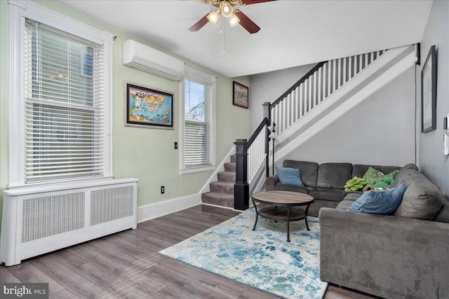 living room featuring ceiling fan, radiator, hardwood / wood-style floors, and a wall unit AC