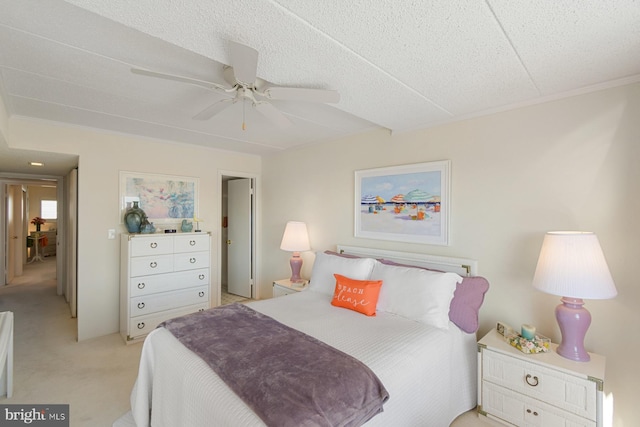 carpeted bedroom with ceiling fan and a textured ceiling