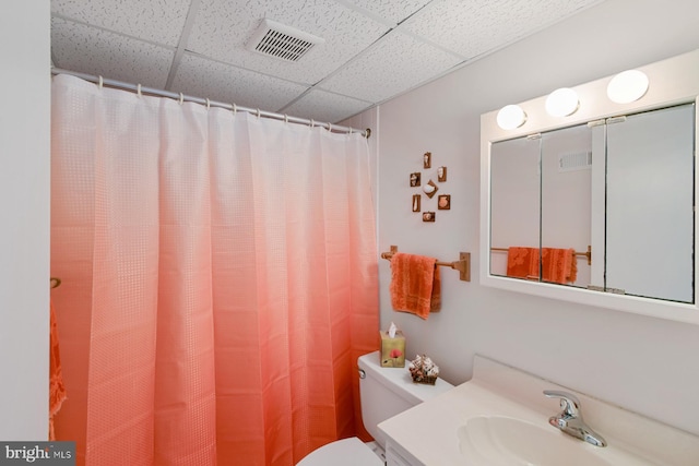 bathroom featuring vanity, toilet, and a paneled ceiling