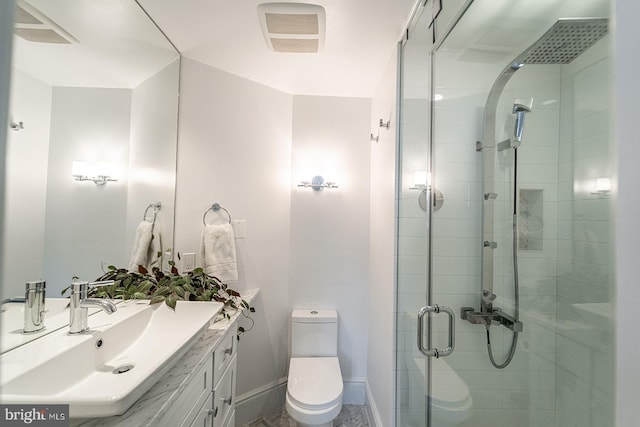 bathroom featuring vanity, toilet, and a shower with shower door