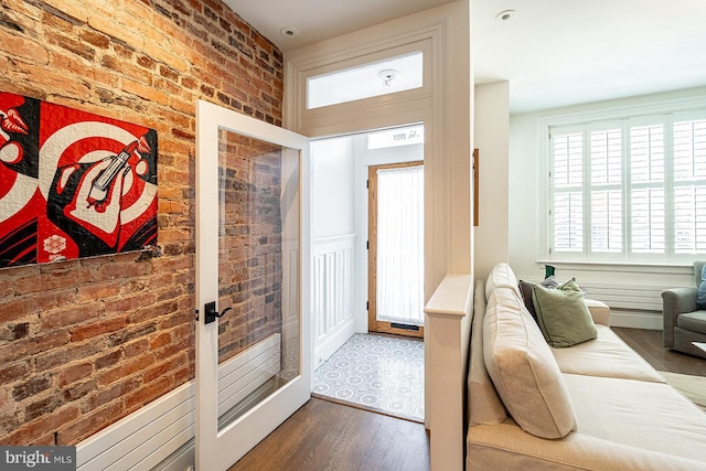 entryway with brick wall and dark hardwood / wood-style floors