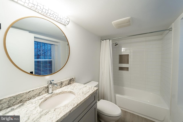 full bathroom featuring vanity, hardwood / wood-style floors, shower / bath combo with shower curtain, and toilet