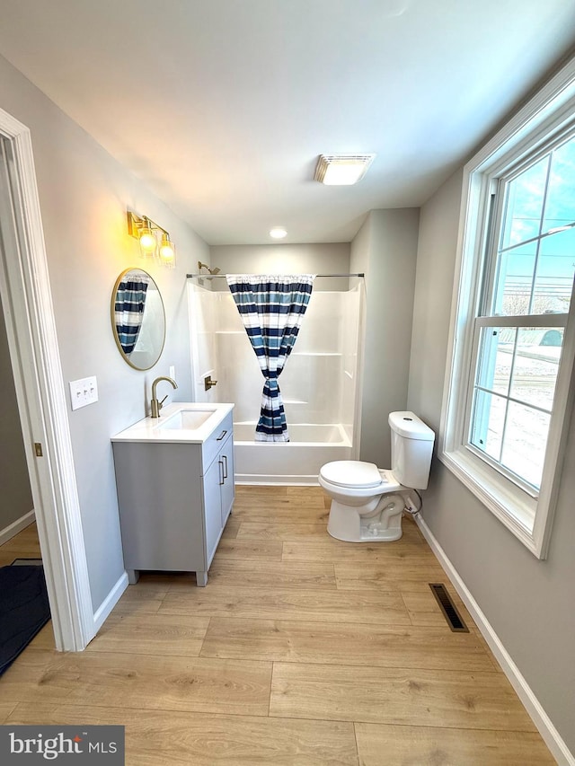 full bathroom featuring wood-type flooring, plenty of natural light,  shower combination, and vanity