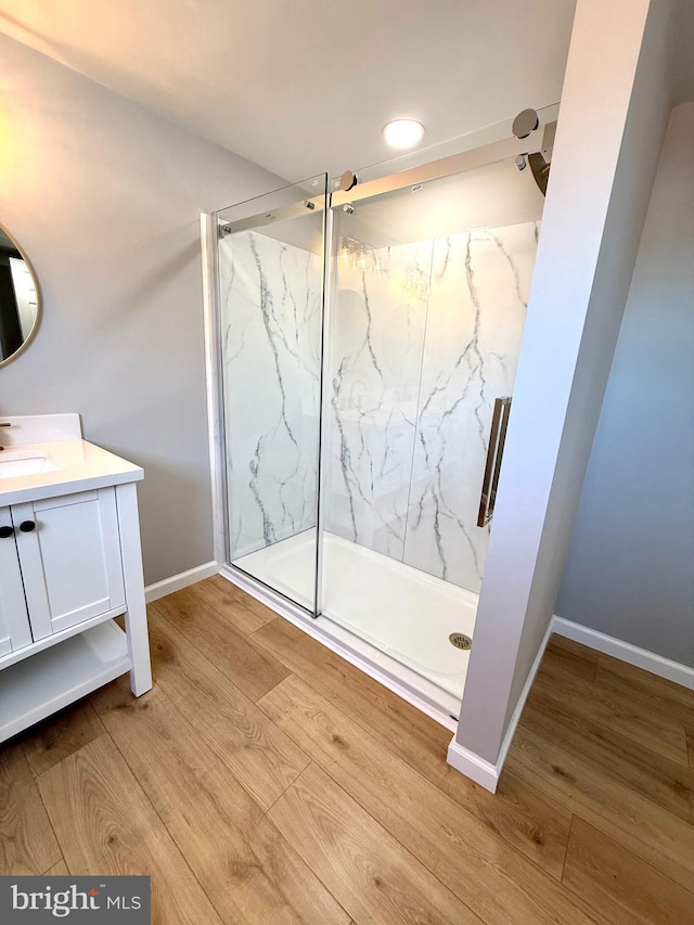 bathroom with vanity, hardwood / wood-style flooring, and a shower with door