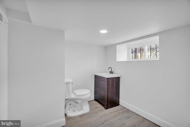 bathroom with vanity, toilet, and hardwood / wood-style flooring