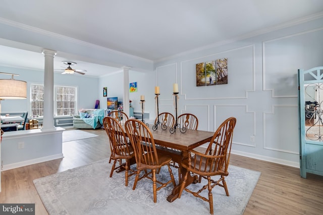 dining area featuring ornate columns, crown molding, ceiling fan, and light hardwood / wood-style flooring