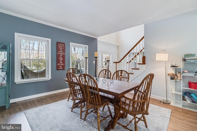 dining room with wood-type flooring and ornamental molding