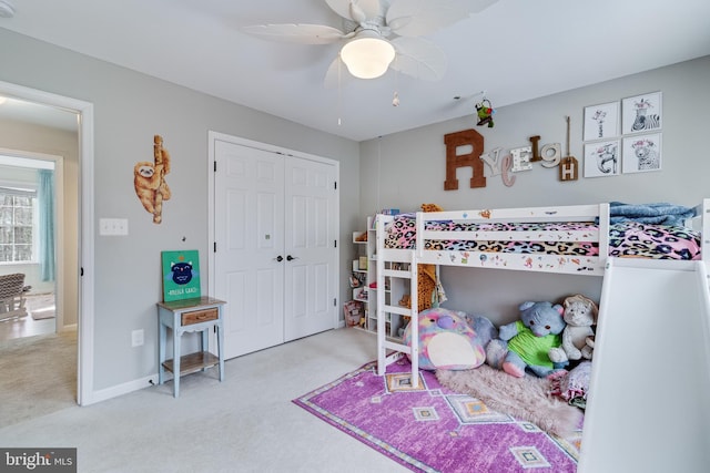 carpeted bedroom featuring ceiling fan and a closet