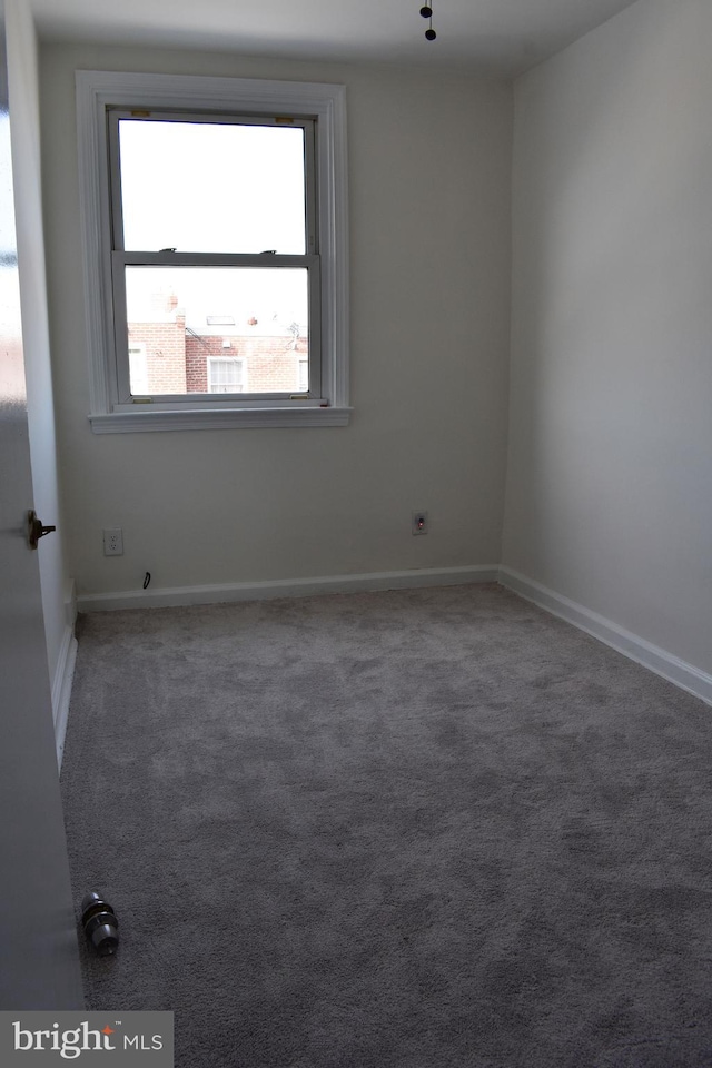 unfurnished room featuring dark colored carpet