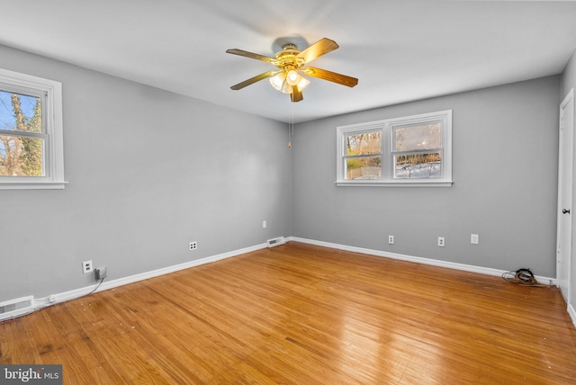 empty room with ceiling fan and light hardwood / wood-style flooring