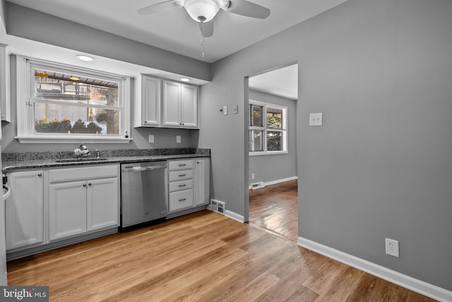 kitchen featuring white cabinets, sink, light wood-type flooring, ceiling fan, and stainless steel dishwasher