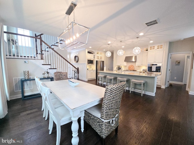 dining room featuring dark hardwood / wood-style flooring and an inviting chandelier