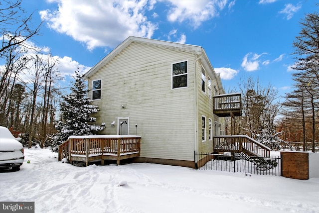 view of snowy exterior featuring a deck