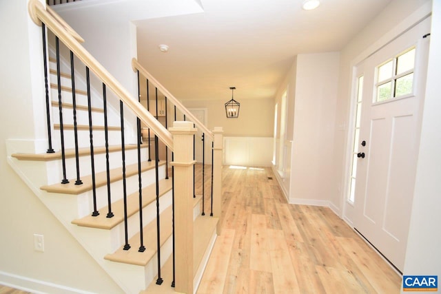 entrance foyer with light wood-type flooring and a chandelier