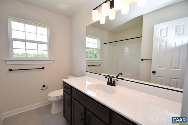 bathroom featuring toilet, vanity, and a shower