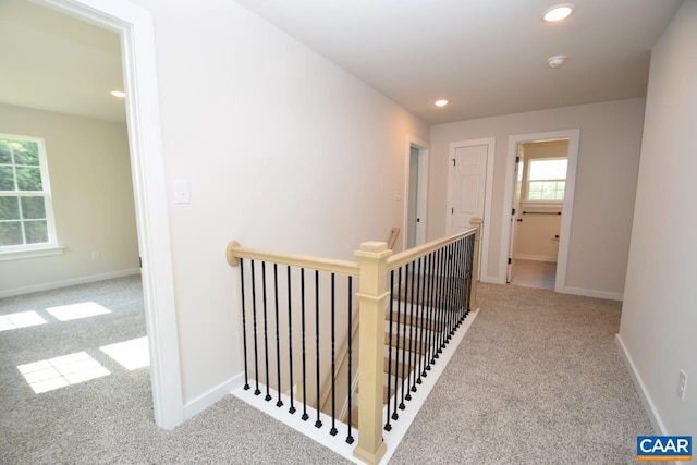 hall with light colored carpet