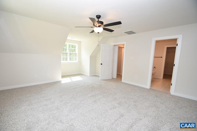 additional living space featuring ceiling fan, light colored carpet, and vaulted ceiling