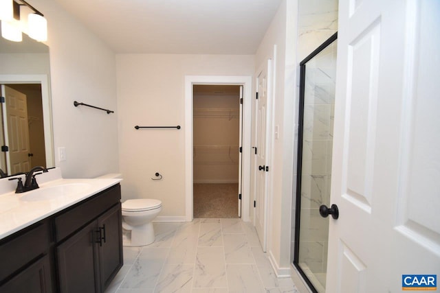 bathroom featuring toilet, a shower with door, and vanity