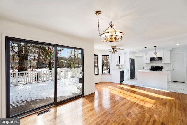 interior space featuring sink, ceiling fan, and light hardwood / wood-style flooring