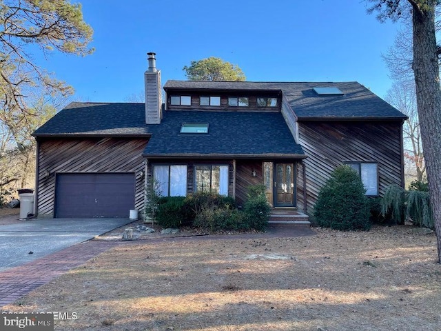 mid-century home featuring aphalt driveway, roof with shingles, a chimney, and an attached garage