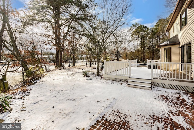 snowy yard with a deck