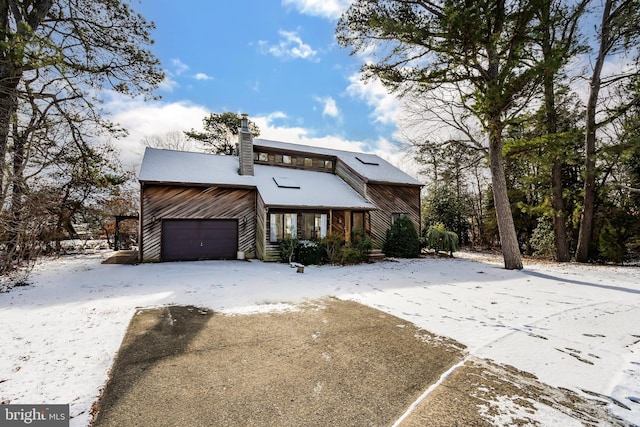 view of front of home with a chimney and an attached garage