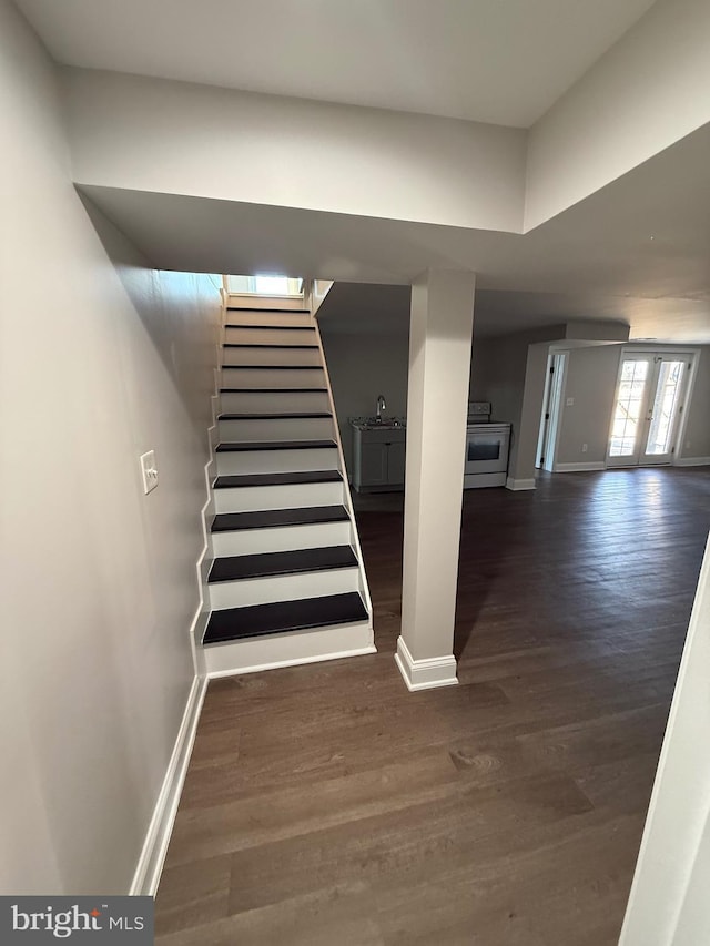 stairs with hardwood / wood-style flooring, sink, and french doors