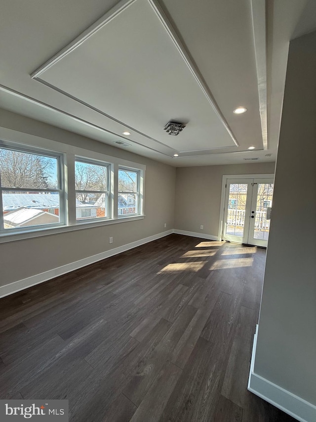 spare room featuring plenty of natural light, dark hardwood / wood-style floors, and french doors