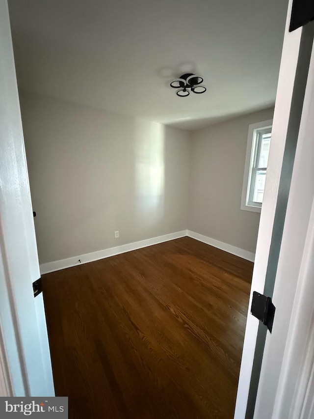 unfurnished room featuring dark hardwood / wood-style flooring