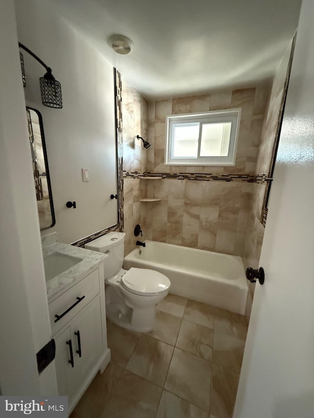 full bathroom featuring vanity, toilet, tile patterned floors, and tiled shower / bath combo