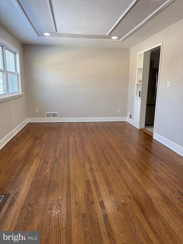 empty room with wood-type flooring and built in features