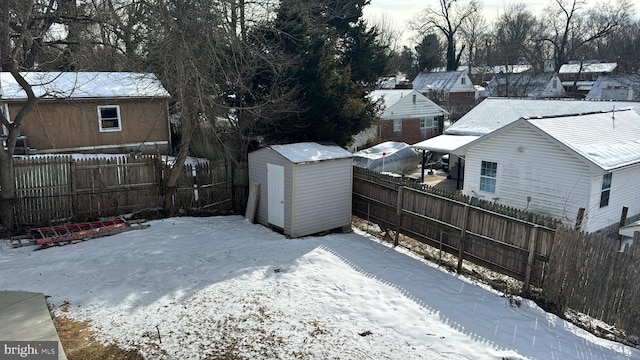 yard covered in snow featuring a storage shed