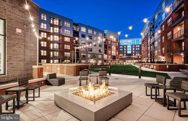 view of property's community featuring a patio and an outdoor fire pit