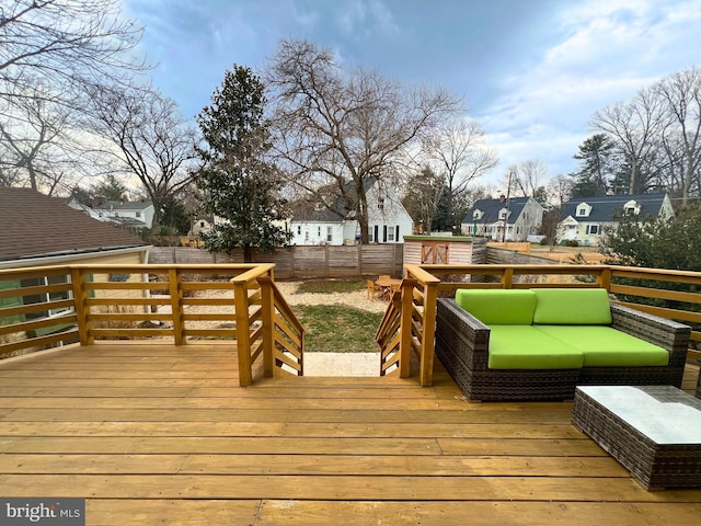 wooden terrace with an outdoor hangout area and a fenced backyard