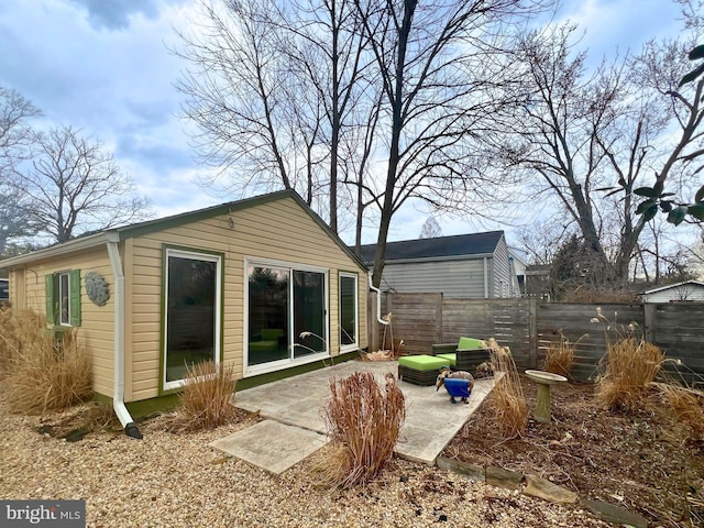 rear view of house with fence and a patio