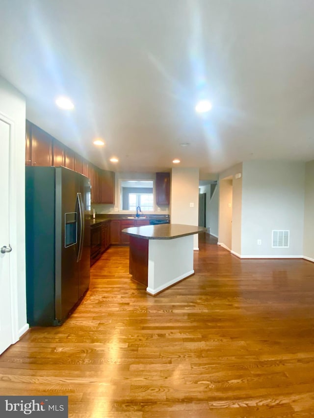 kitchen featuring stainless steel fridge with ice dispenser, light hardwood / wood-style flooring, and sink