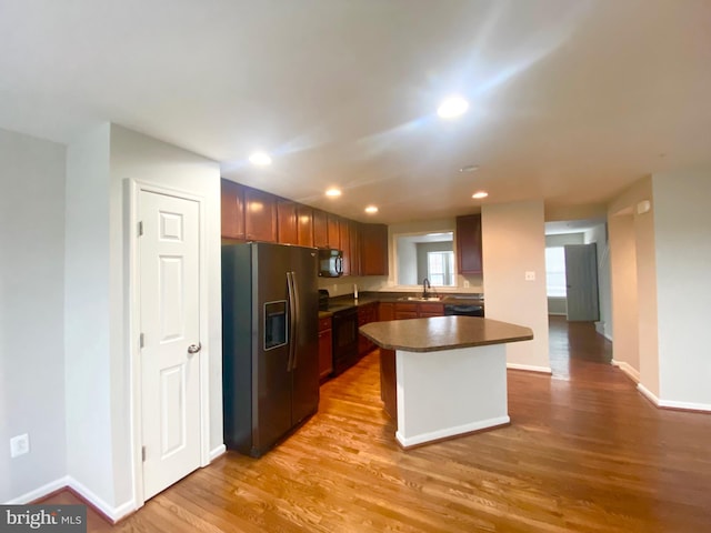 kitchen featuring light hardwood / wood-style floors, sink, and black appliances