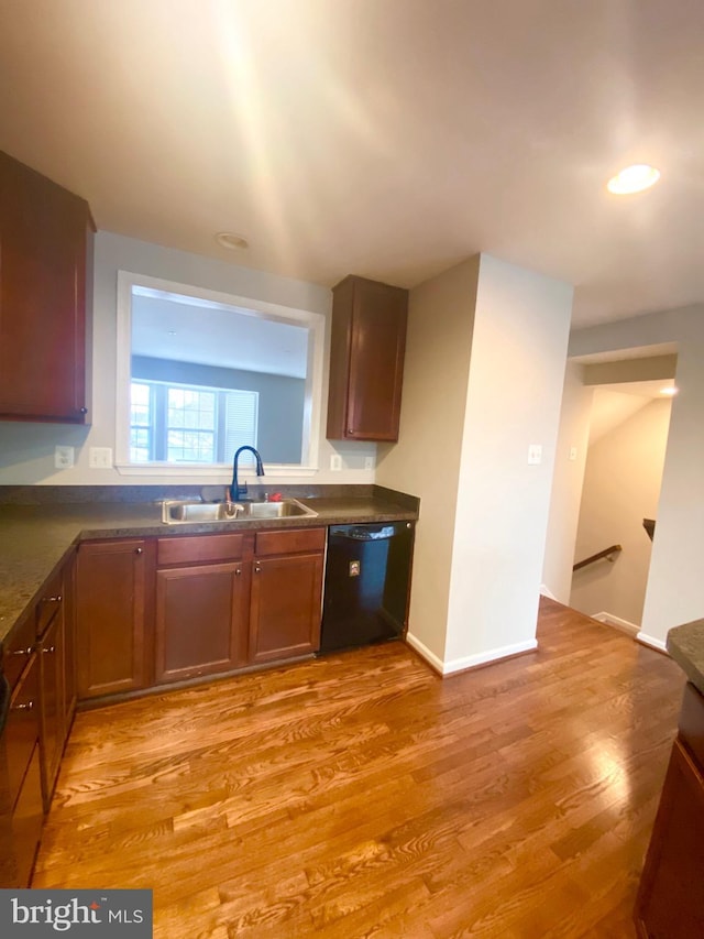 kitchen with dishwasher, sink, and light wood-type flooring