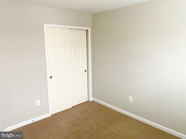 unfurnished bedroom with carpet flooring and a closet