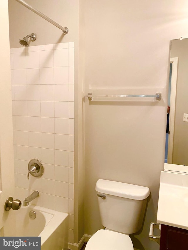 full bathroom featuring vanity, tiled shower / bath combo, and toilet