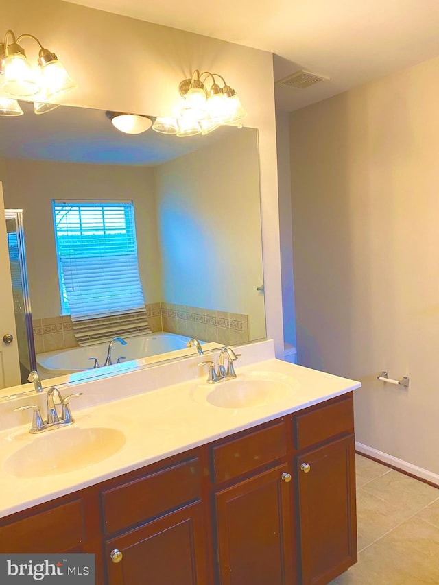 bathroom with vanity, a bath, and tile patterned floors