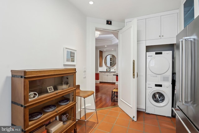 laundry room featuring tile patterned floors and stacked washing maching and dryer