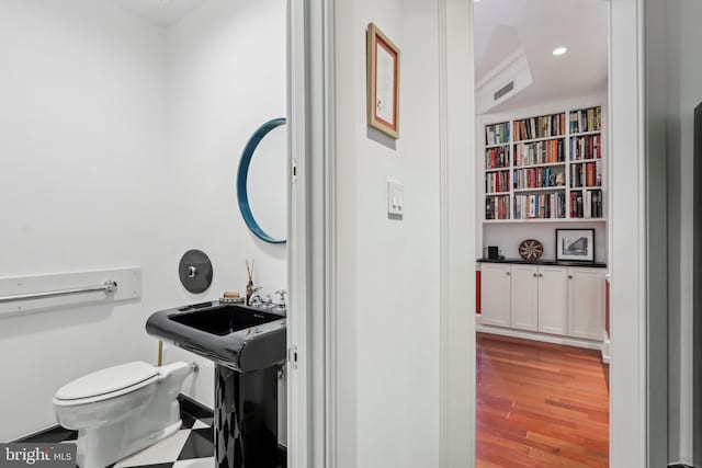 bathroom featuring hardwood / wood-style flooring and toilet