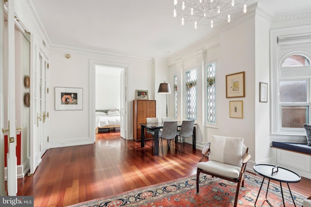 sitting room featuring dark hardwood / wood-style floors, crown molding, and a chandelier